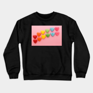 Heart-shaped Candy arranged in rainbow order on a pink background Crewneck Sweatshirt